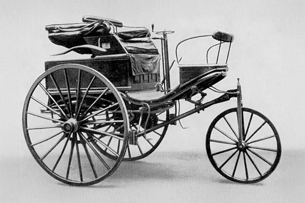     Benz Patent Motorwagen - büyük jantlı tekerlekleri, ince, kavisli şasisi ve döşemeli koltuğu olan üç tekerlekli bir araç, koltuğun arkasında tahrik ünitesi bulunmaktadır

