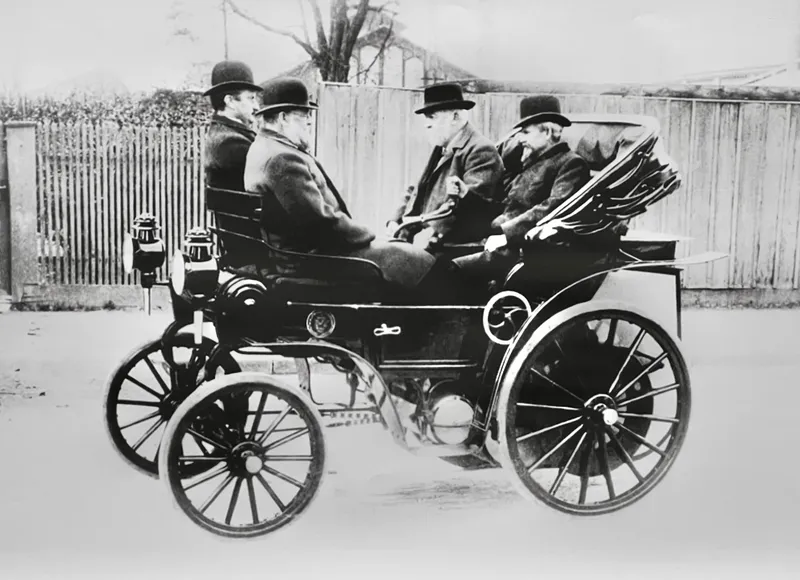    Gottlieb Daimler in Cannstatt in 1891, sitting in an early motor car with his son Adolf Daimler, designer Wilhelm Maybach and another person.
