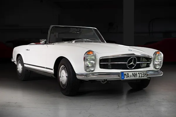     W113 Pagode Paula Bracqa – pojazd w wersji białego kabrioletu, sfotografowany z otwartym dachem, zaprojektowany przez głównego projektanta Mercedes Benz
